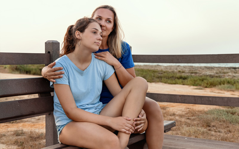 Mom embracing her teen daughter who is struggling with mental health.