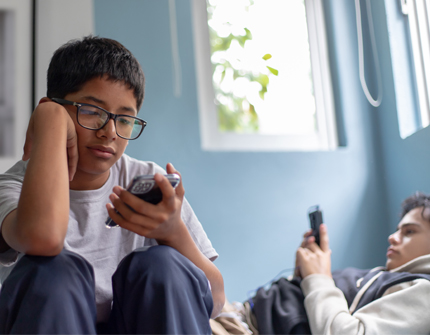 Teenage boys on their phones in summer.